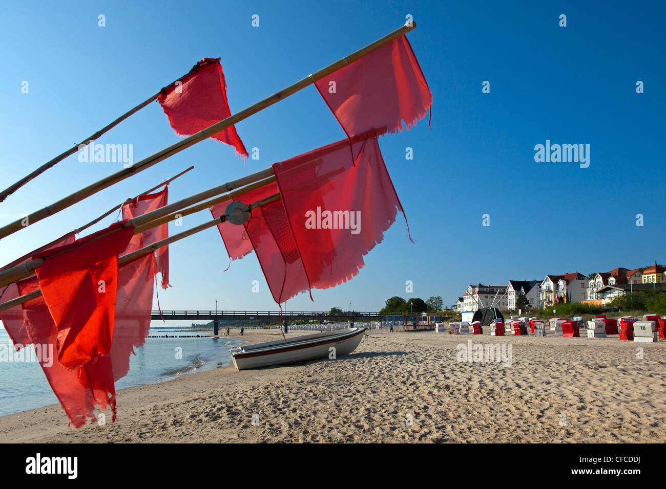Fishing boat and red flags on the beach, Bansin seaside resort, Usedom island, Baltic Sea, Mecklenburg-West Pomerania, Germany Stock Photo