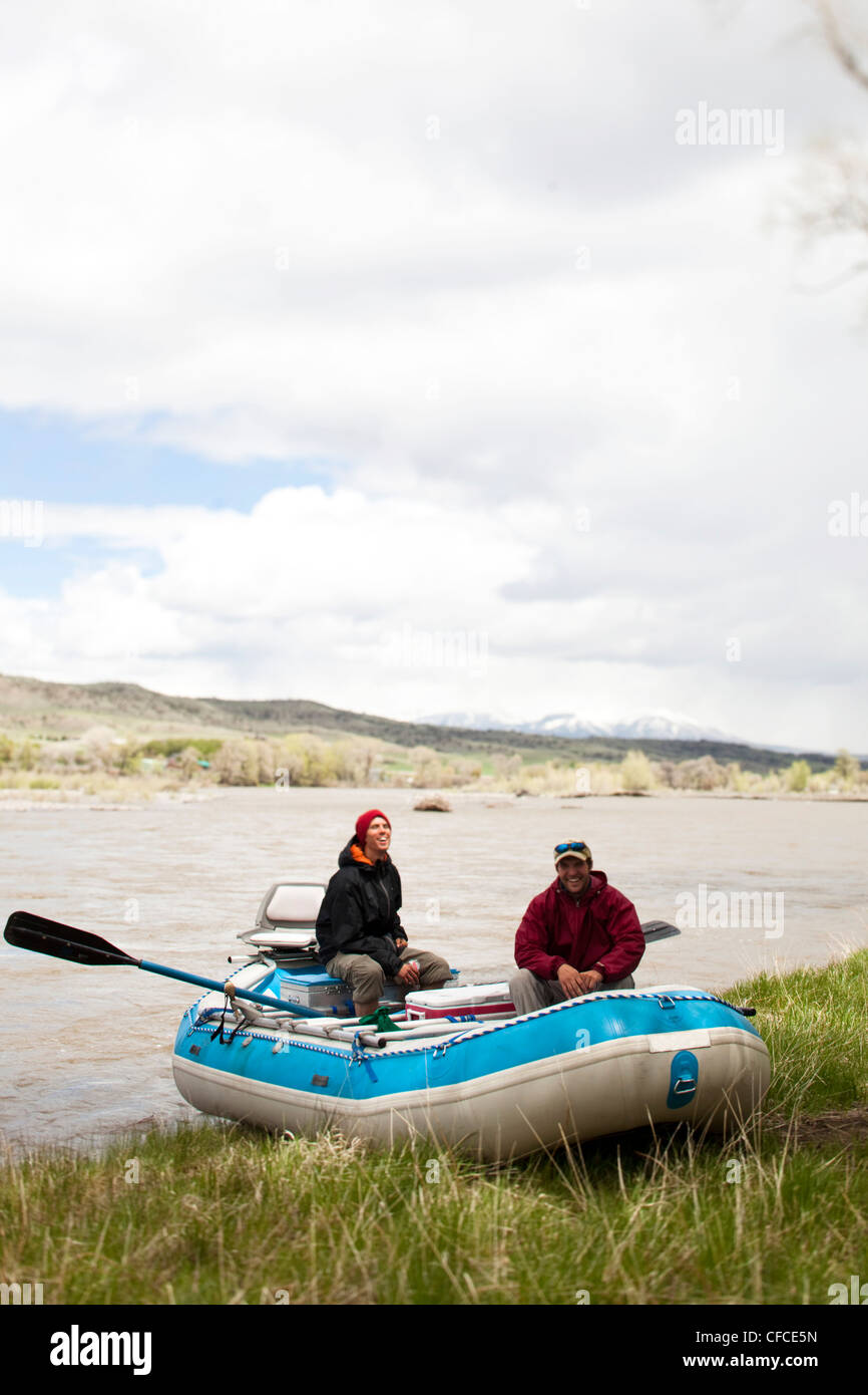 Two men smile while sitting on there raft in Montana. Stock Photo