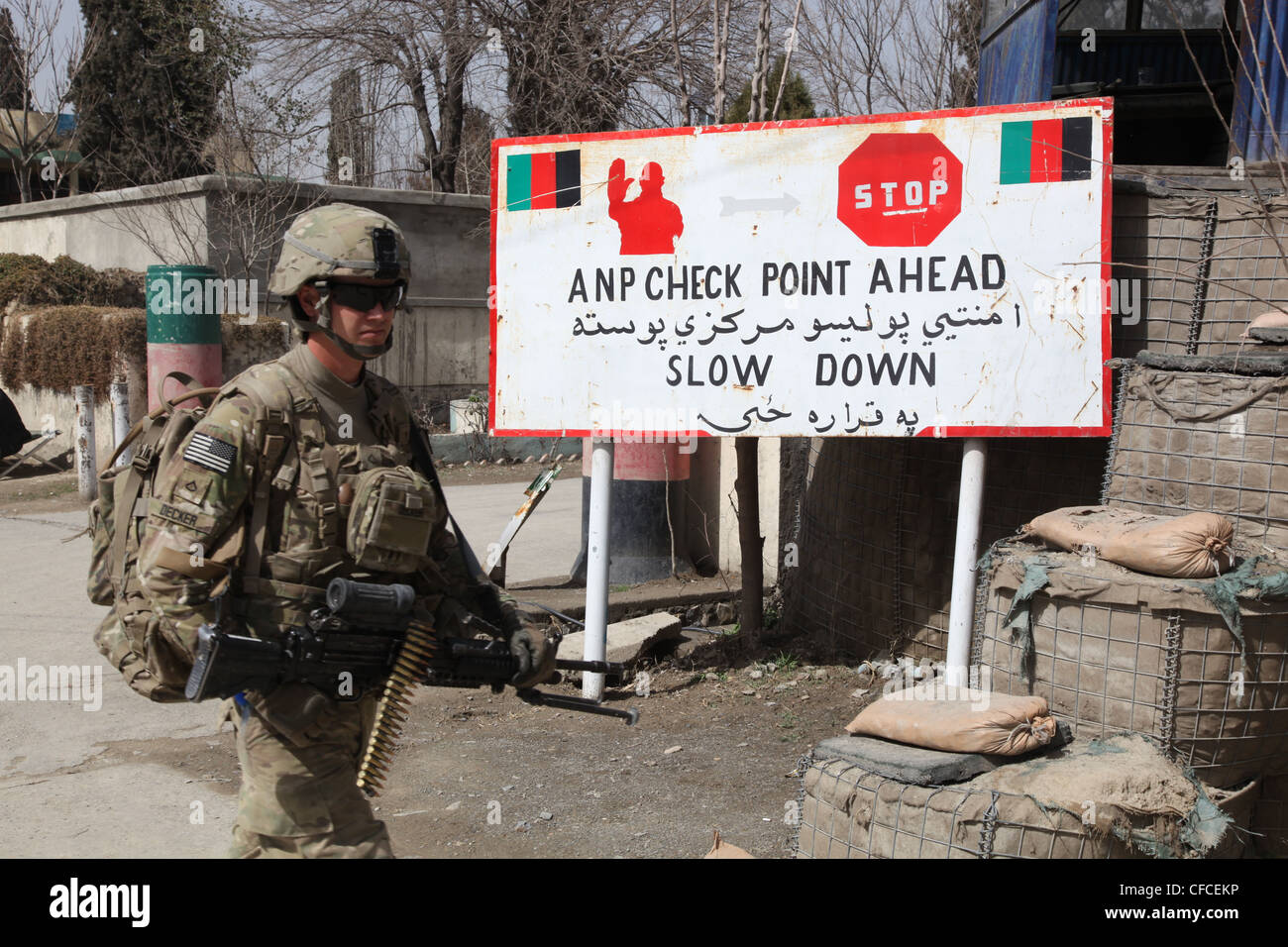 U.S. Army Pfc. Joseph Decker, from Guymon, Okla., of 1st Platoon, Alpha Battery, 2nd Battalion, 377th Parachute Field Artillery Regiment, Task Force Steel, marches in front of a check-point at the Khowst Prevention Headquarters in Khowst City, March 5 To demonstrate cooperation, coalition forces meet and talk weekly about ways to work better and increase support of one another for the security of the citizens of the province. Stock Photo