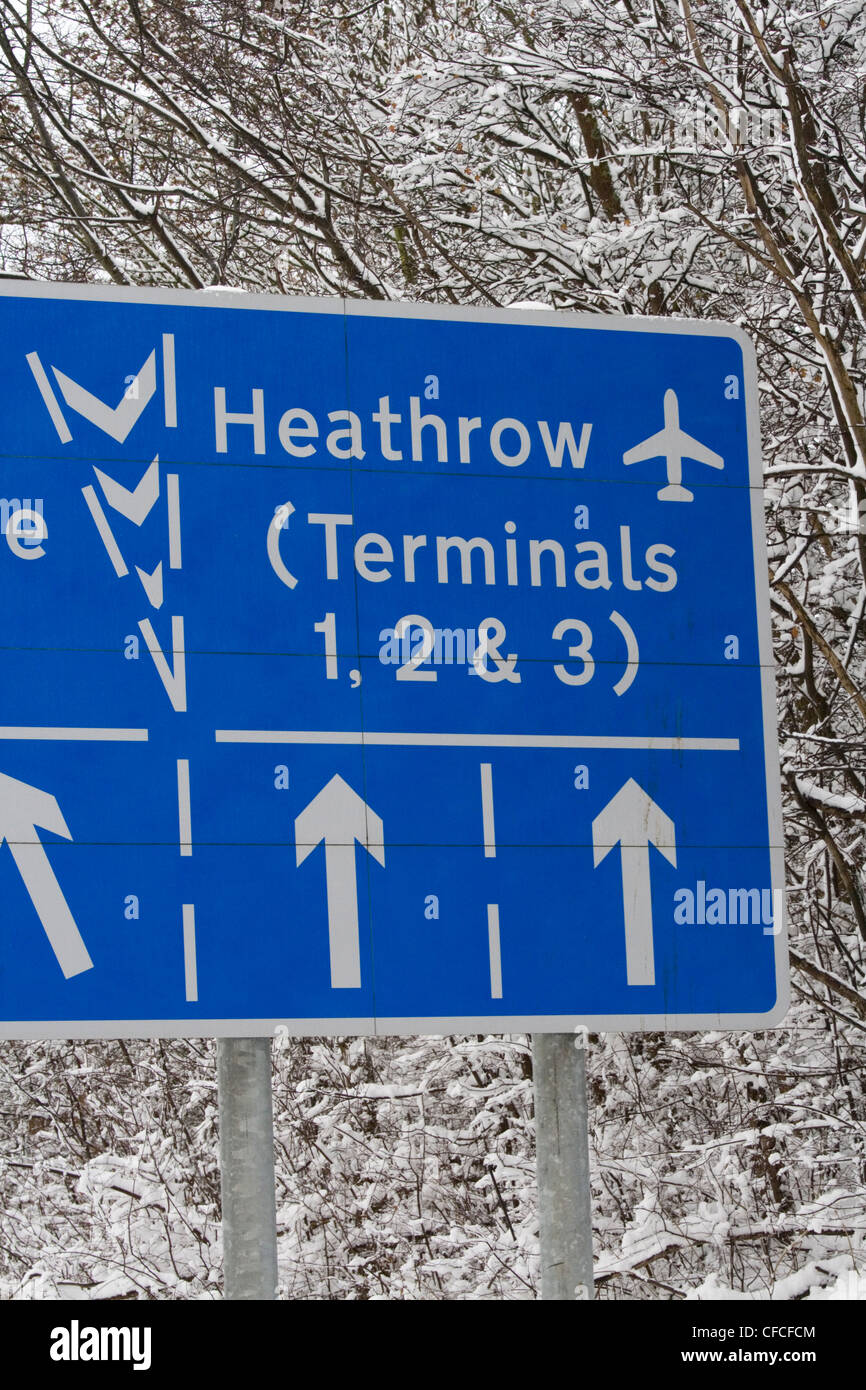Road sign for Heathrow Airport on M4 during heavy snow disruption. Stock Photo