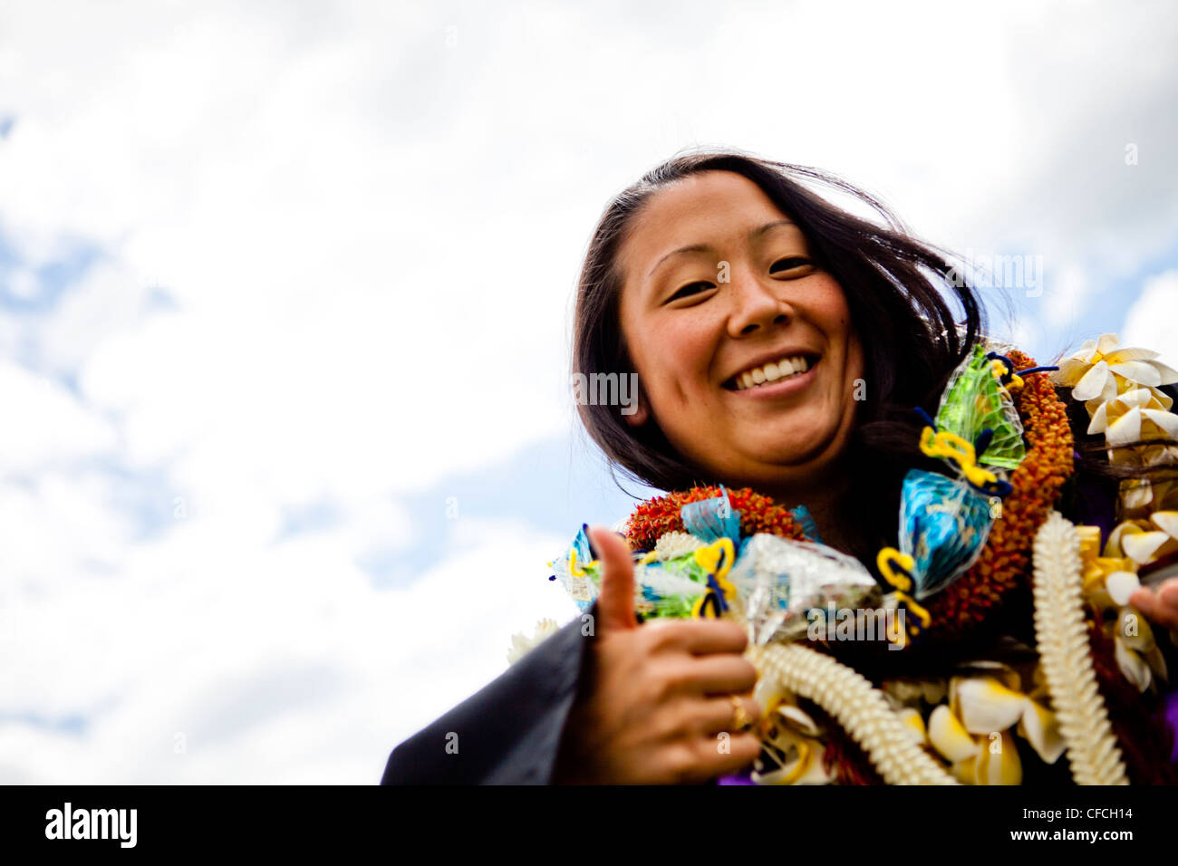 a graduate is shrouded in Hawaiian Leis (lays) on her graduation day from the University of New Haven. Stock Photo