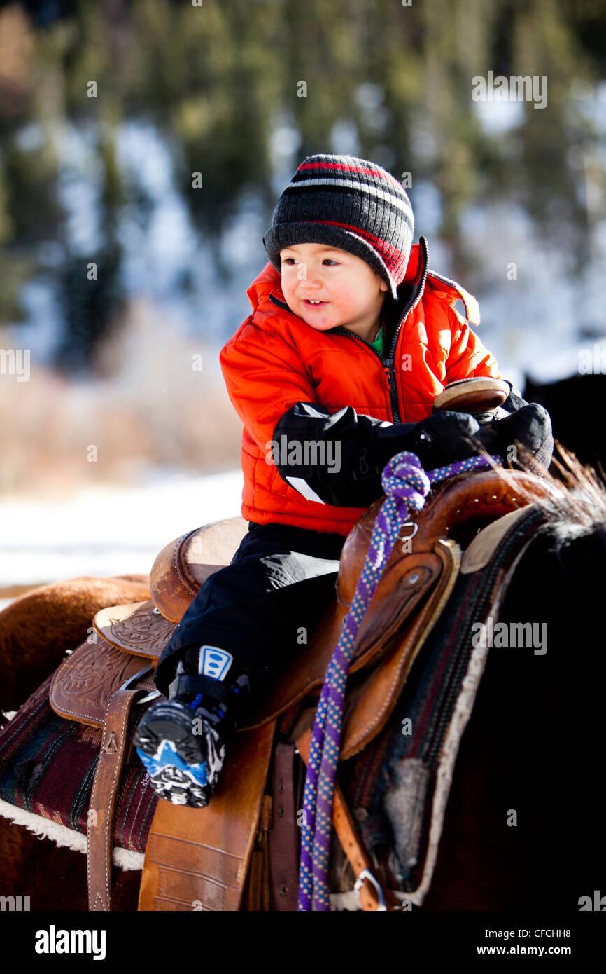 a little boy rides a horse while 