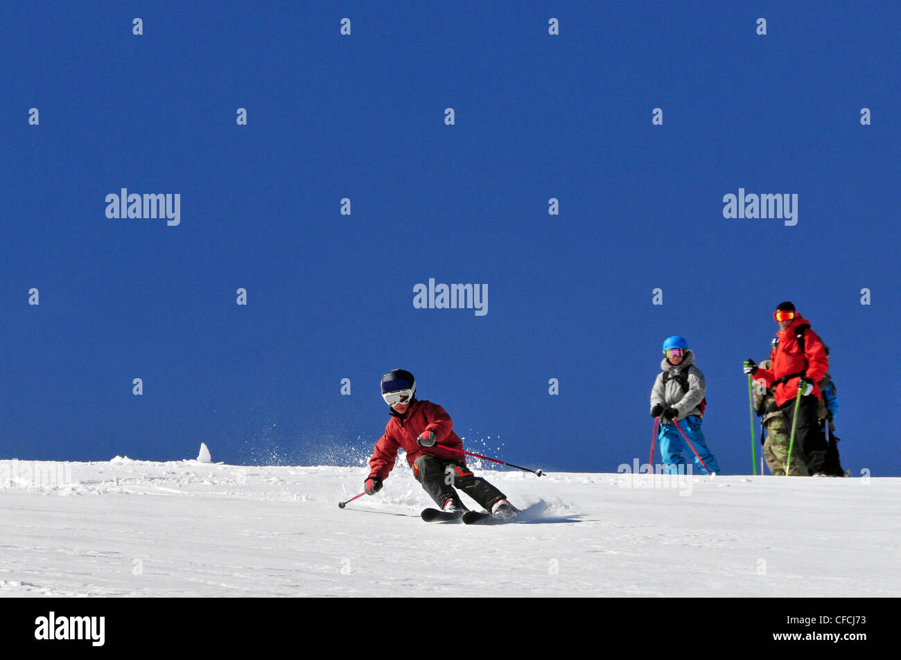 A young male skier skiing in the backcountry while his instructor looks on at Kirkwood Mountain Resort, CA. Stock Photo