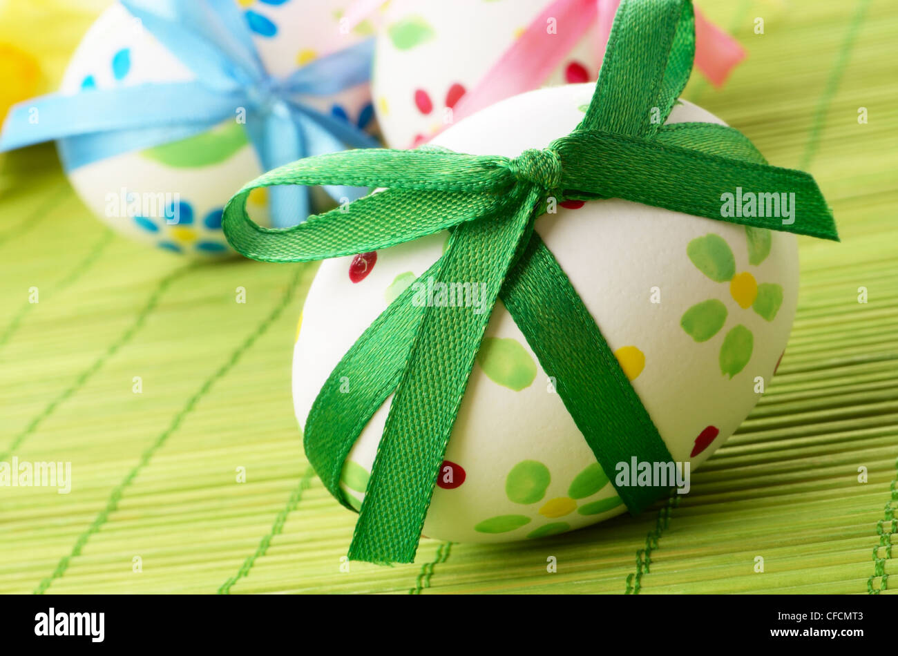 Easter eggs with bows over green background Stock Photo - Alamy