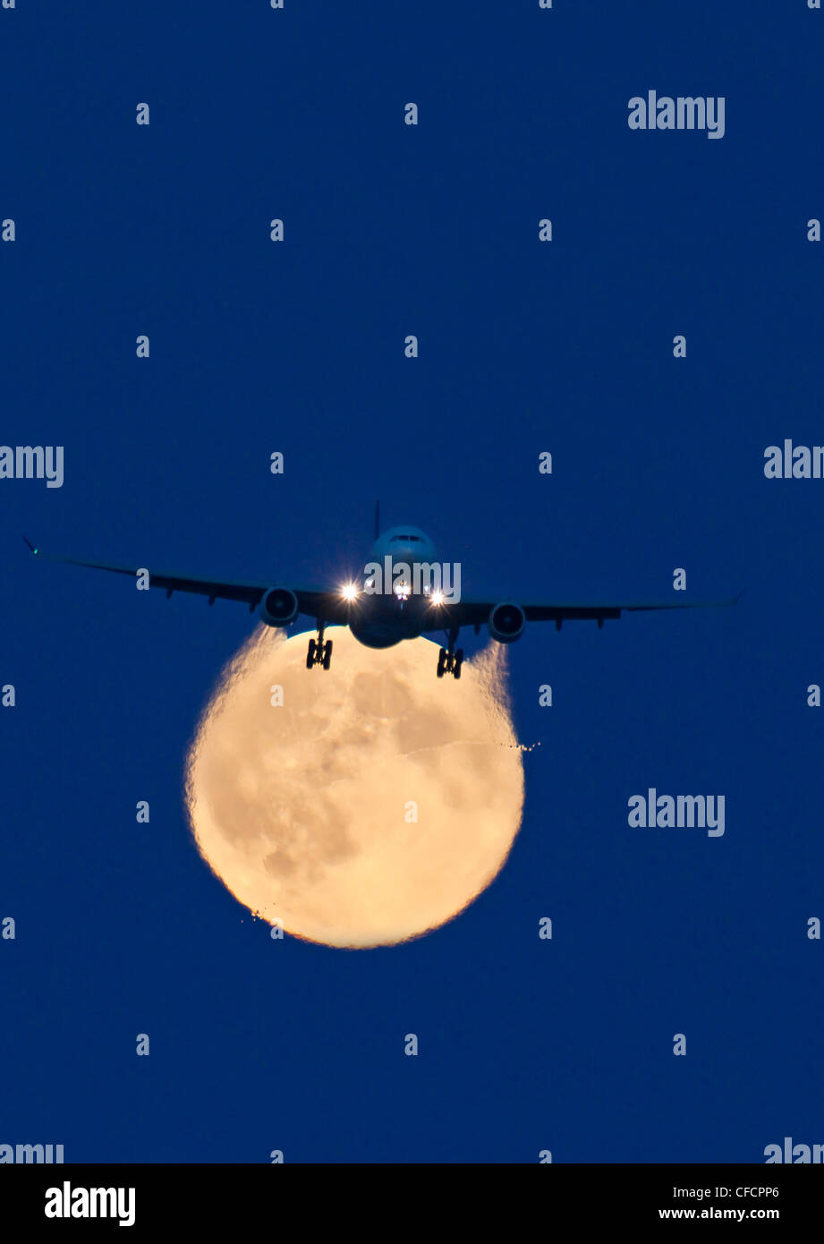 Airbus 330 passing full moon approach Vancouver Stock Photo