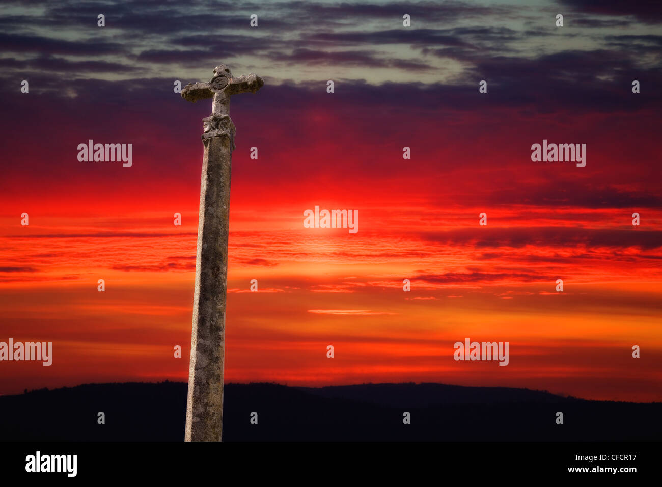 stone cross with the sunset as background Stock Photo
