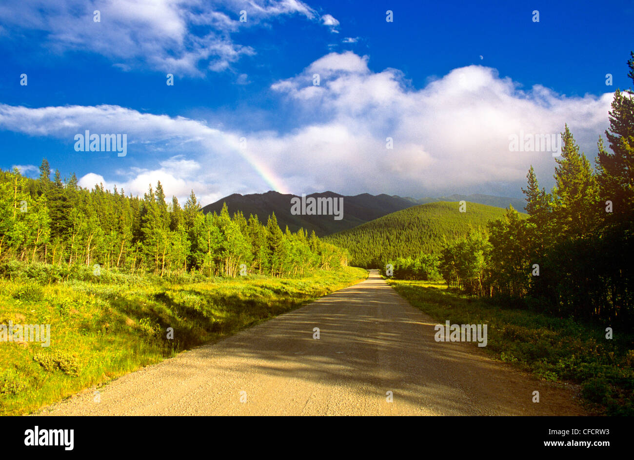 Rainbow over dirt road, Kananaskis County, Alberta, Canada Stock Photo
