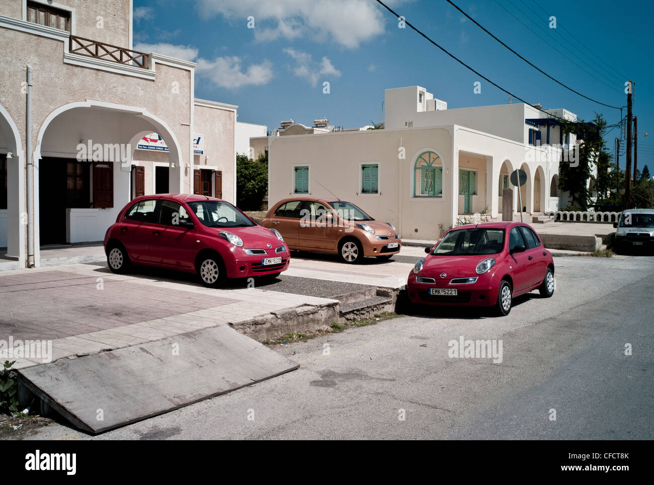 Three rental cars, Nissan Micra, outside a Car Rental office on a Greek