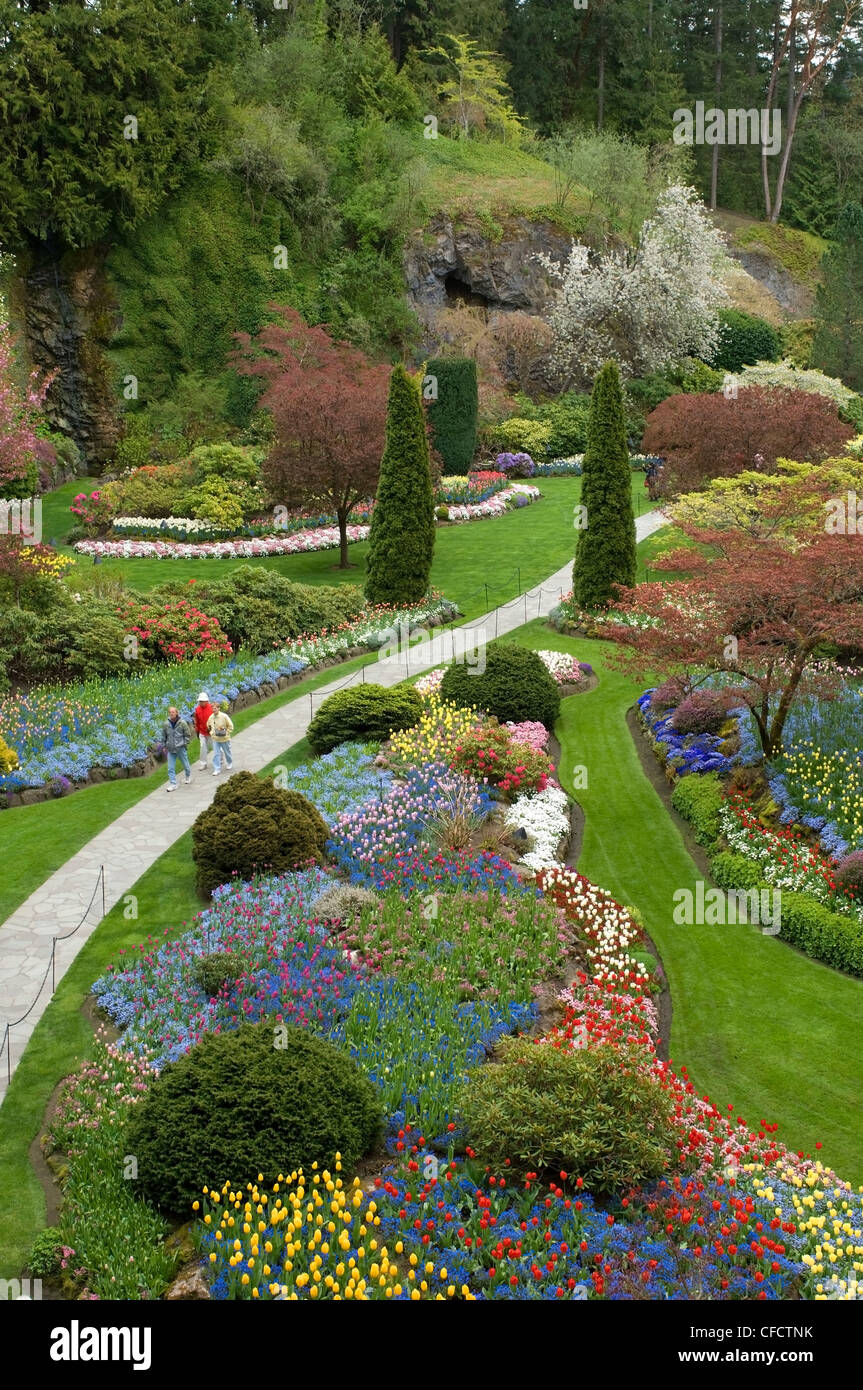 Tourists walking through Sunken Garden in springtime, Butchart Gardens, Victoria, Vancouver Island, British Columbia, Canada Stock Photo