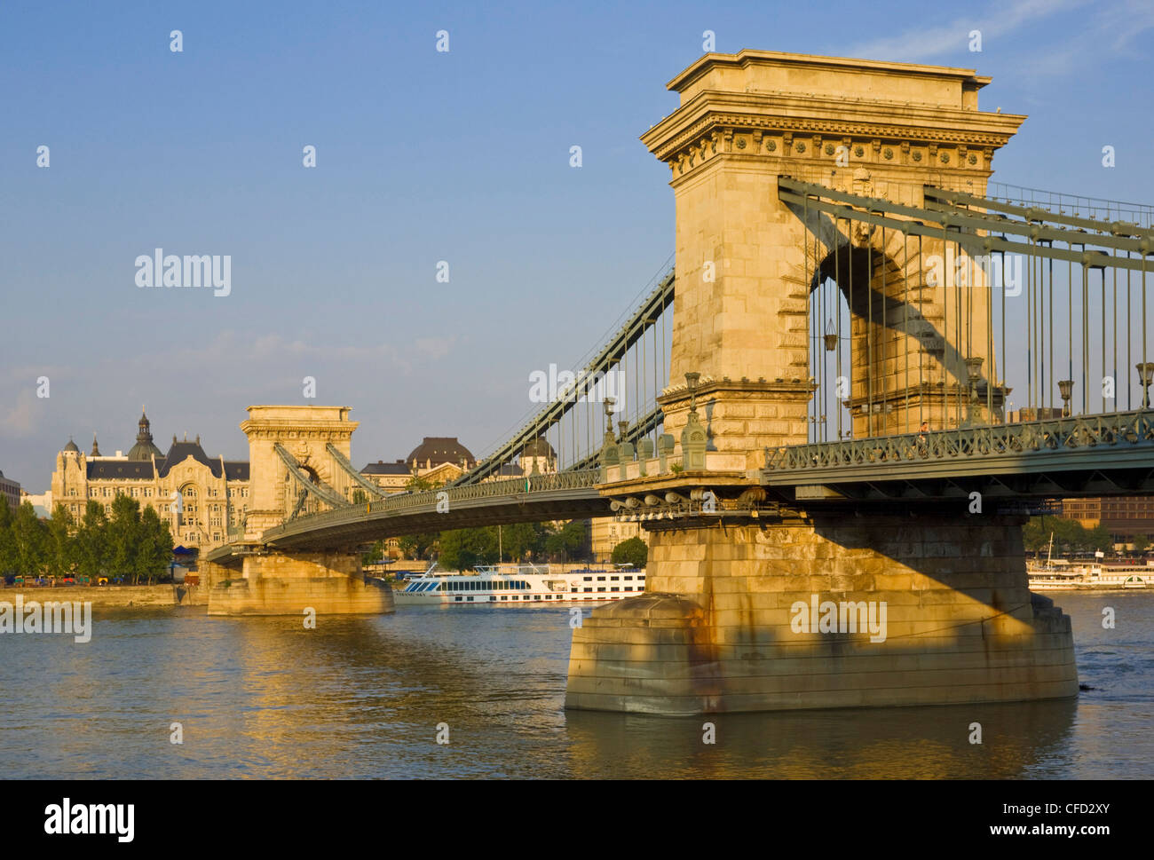 The Chain Bridge (Szechenyi Lanchid), over the River Danube with the Gresham Hotel and cruise boats behind, Budapest, Hungary Stock Photo