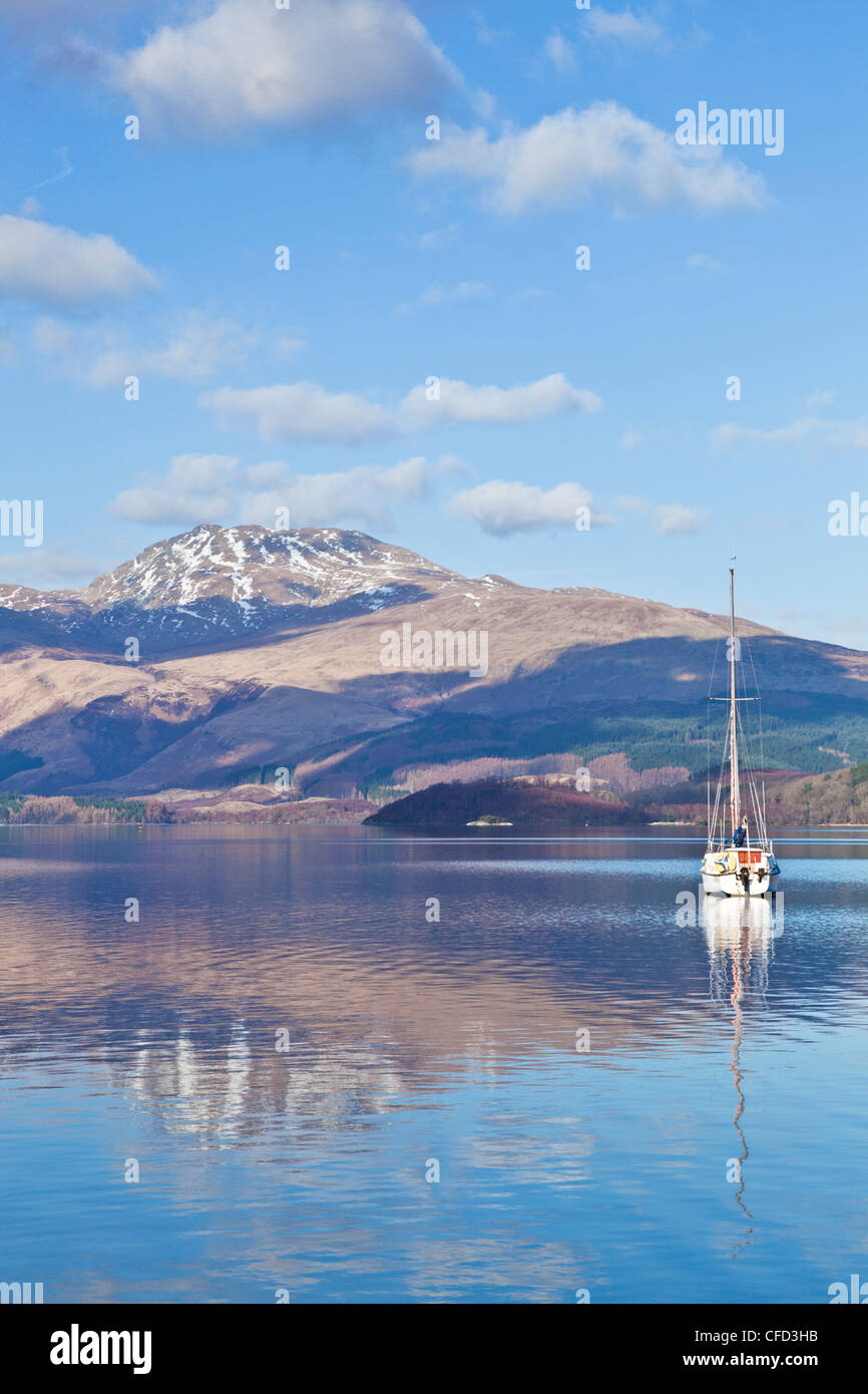 Loch Lomond with sailing boat, snow covered Beinn Uird behind, from Luss Jetty, Luss, Argyll and Bute, Scotland, UK Stock Photo