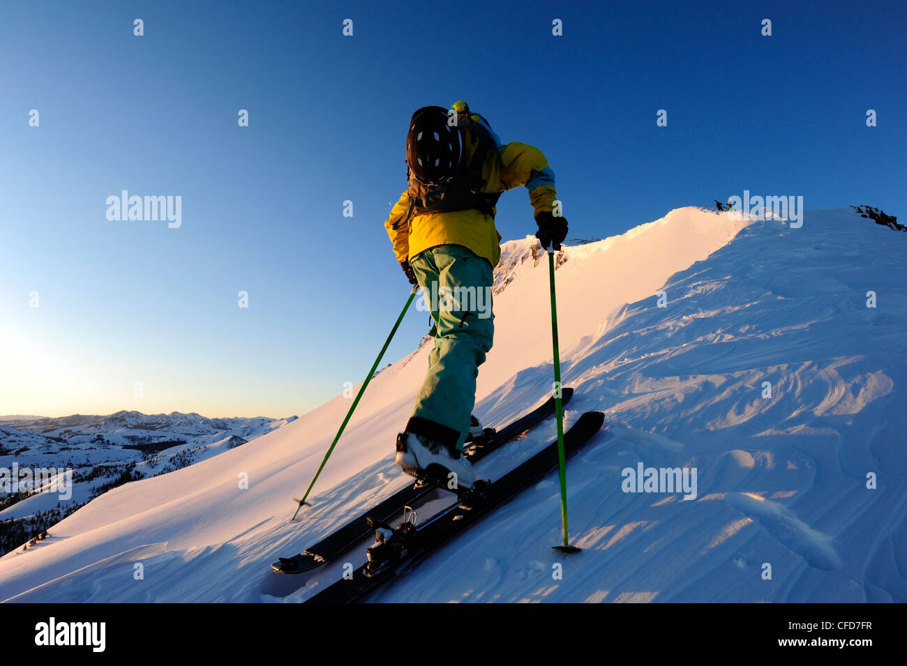 A skier skinning up a snow covered slope at sunrise in the Sierra Nevada near Lake Tahoe, California. Stock Photo