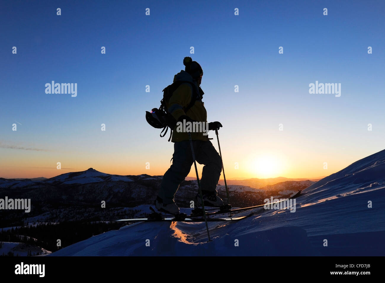 A silhouette of a skier watching sunrise in the Sierra Nevada near Lake Tahoe, California. Stock Photo