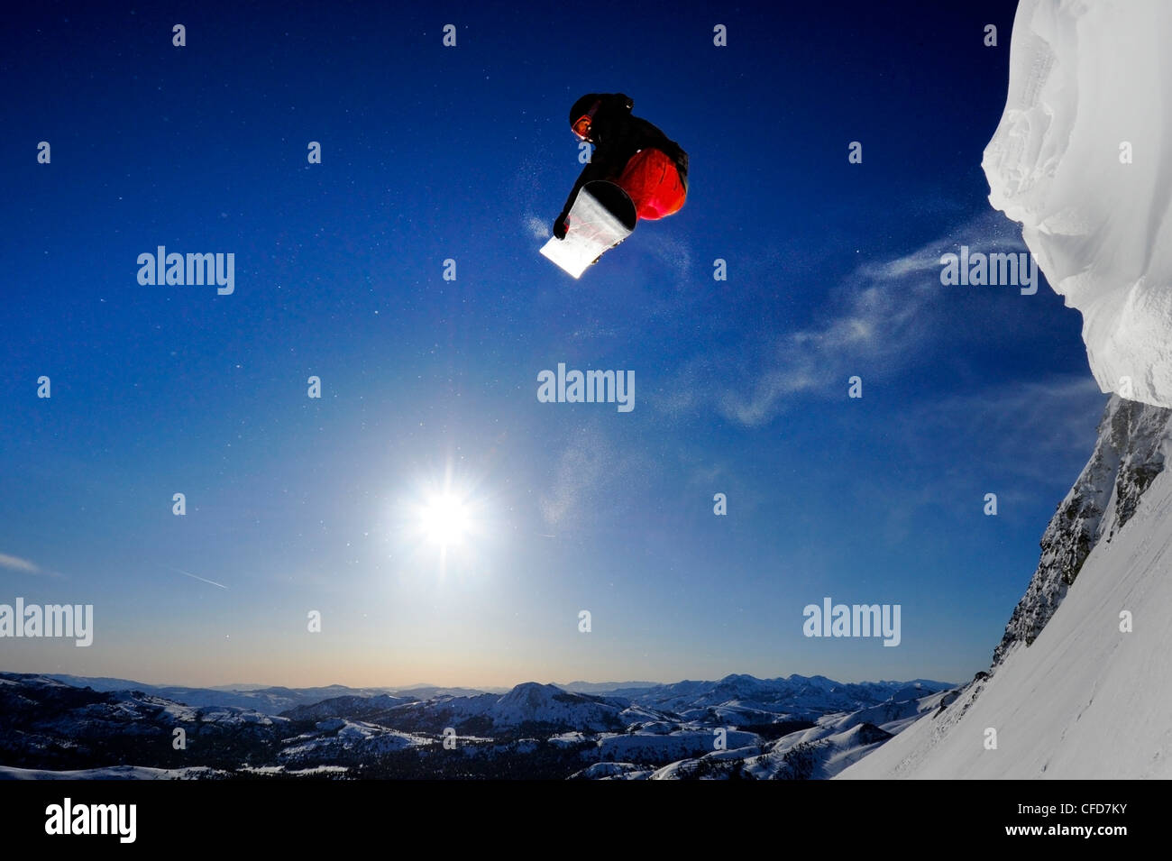 A snowboarder soaring in the air at sunrise in the Sierra Nevada mountains near Lake Tahoe, California. Stock Photo