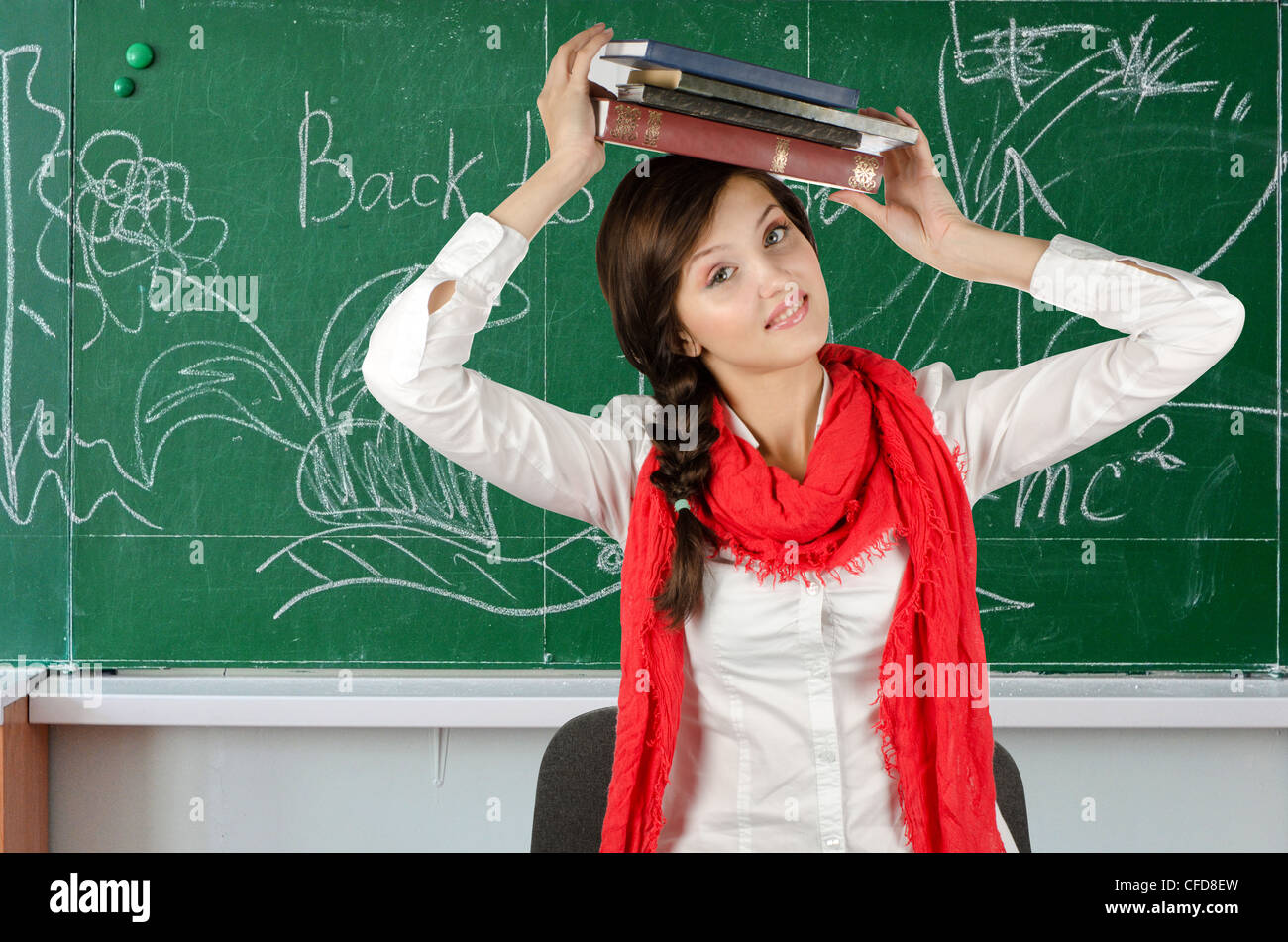 Young student girl with her books at blackboard background Stock Photo ...