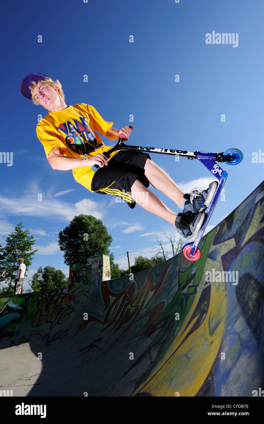 Young man performing jump with scooter, skate park, Munich, Upper Stock