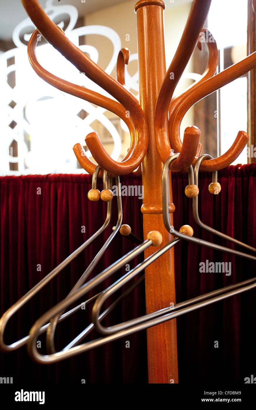 Wooden Coat rack with metal hangers in little French restaraunt Stock Photo