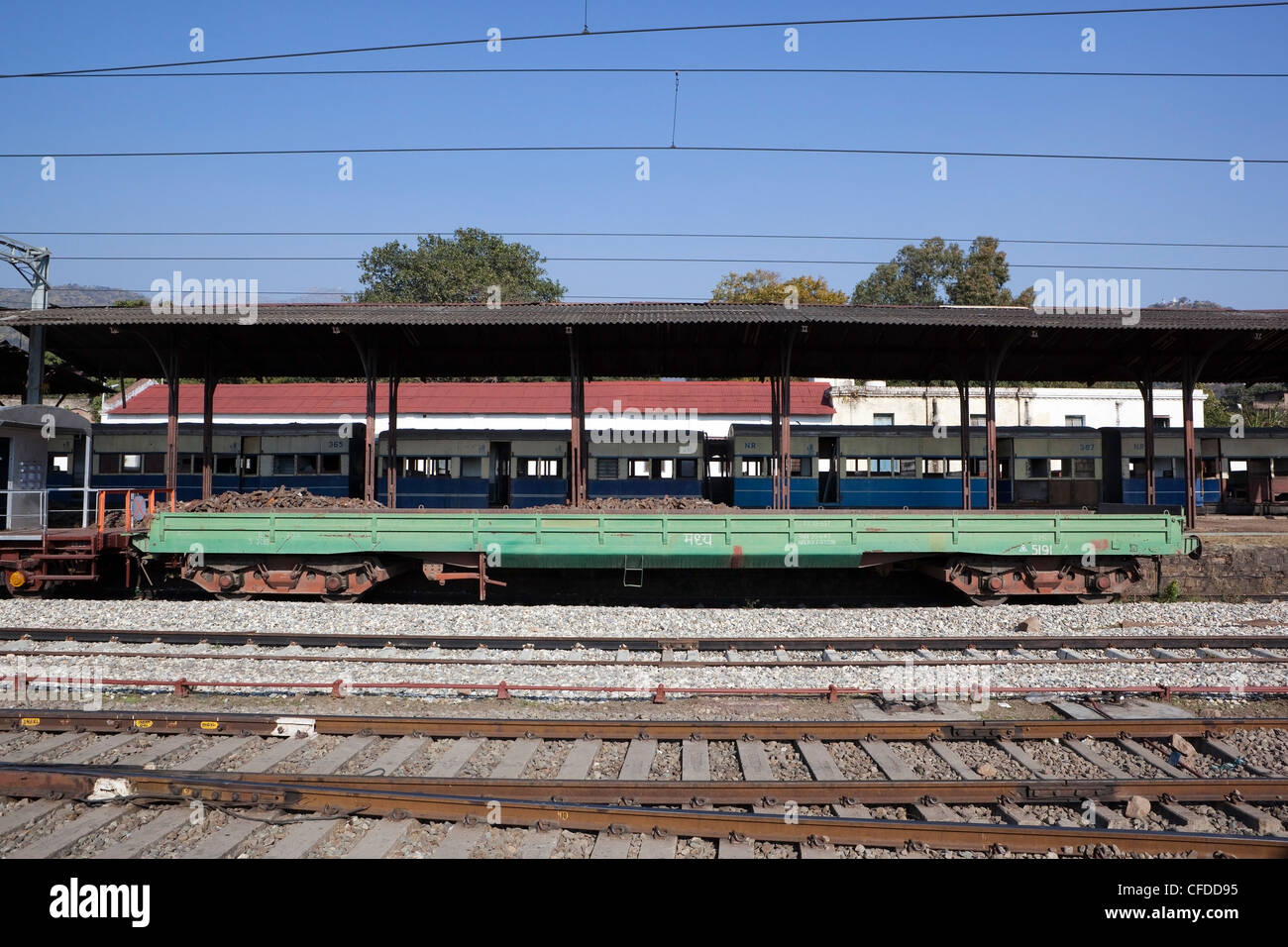 rolling stock at Kalka railway station beside a platform with railway tracks and electrified cables in the state of Haryana, India Stock Photo
