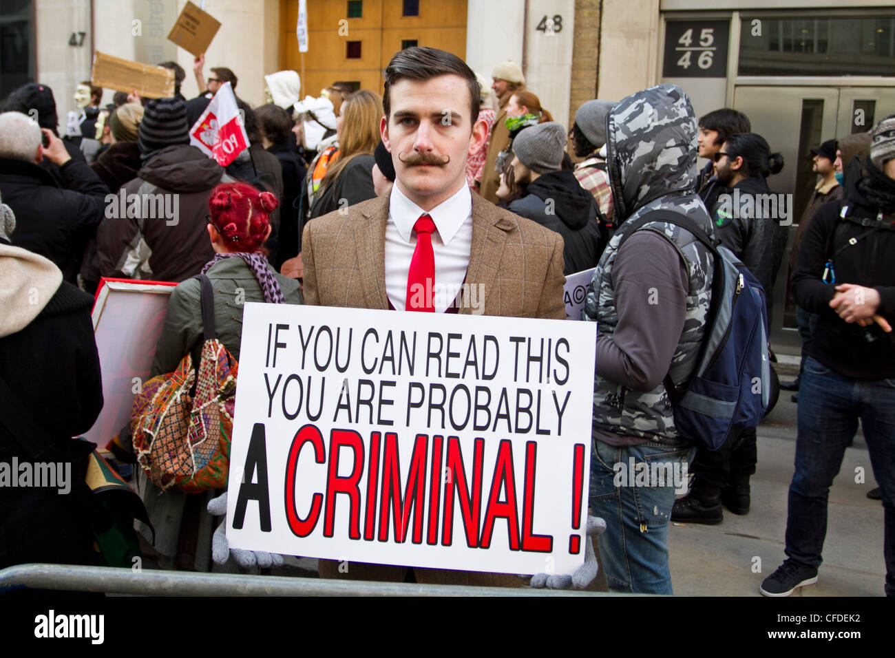 London, UK 11th February, ACTA protest London, A protester with a placard that reads 'If you can read this you are a criminal' Stock Photo