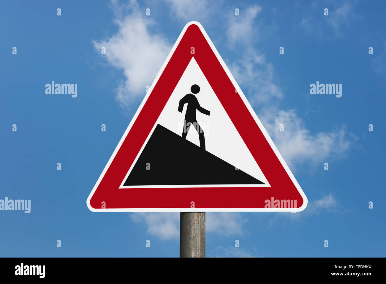 Detail photo of a danger sign 'Steep hill downwards', a man goes down, background sky. Stock Photo