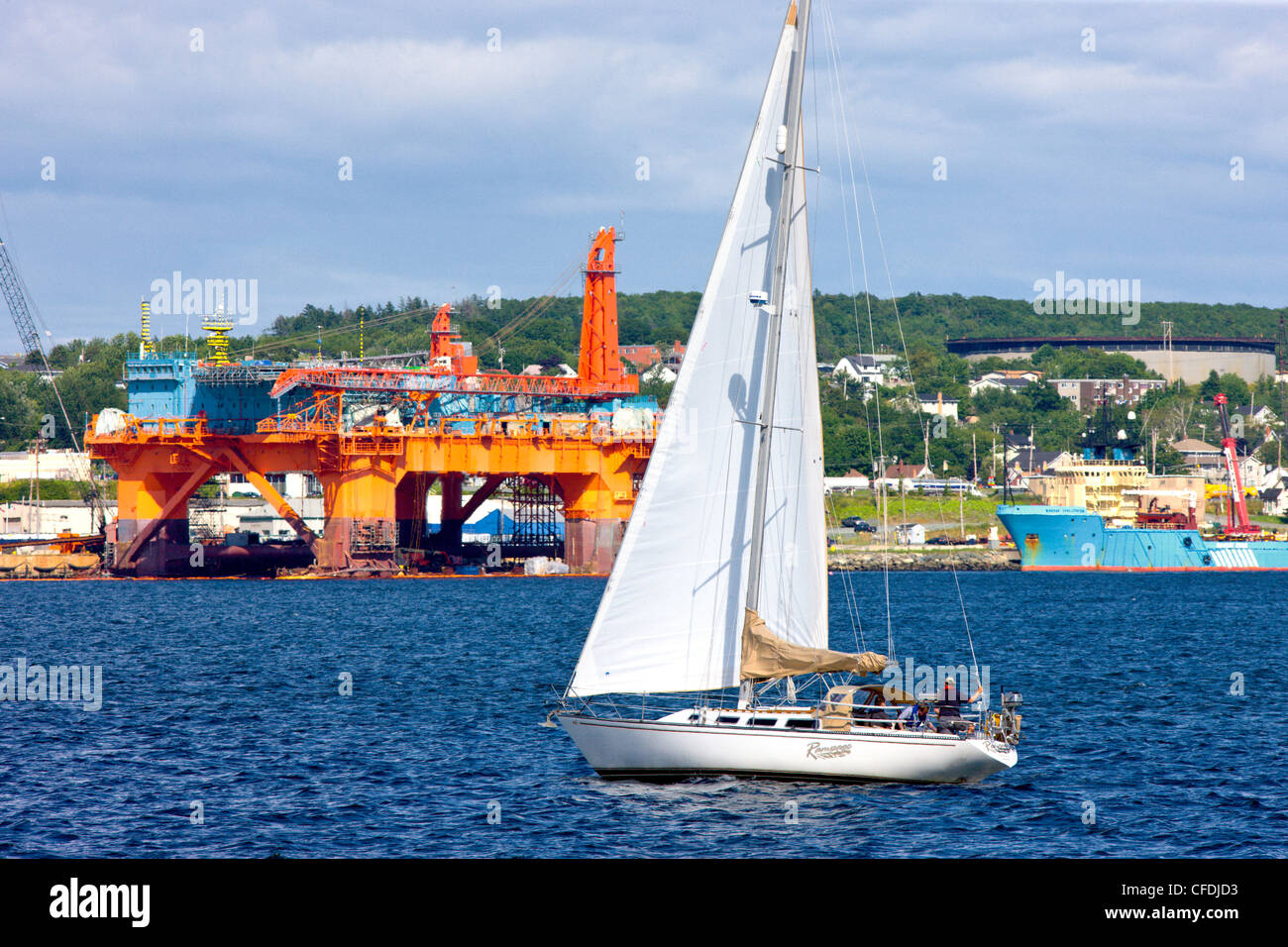 Sailboat in front of Oil rig, Halifax Harbour, Nova Scotia, Canada Stock Photo