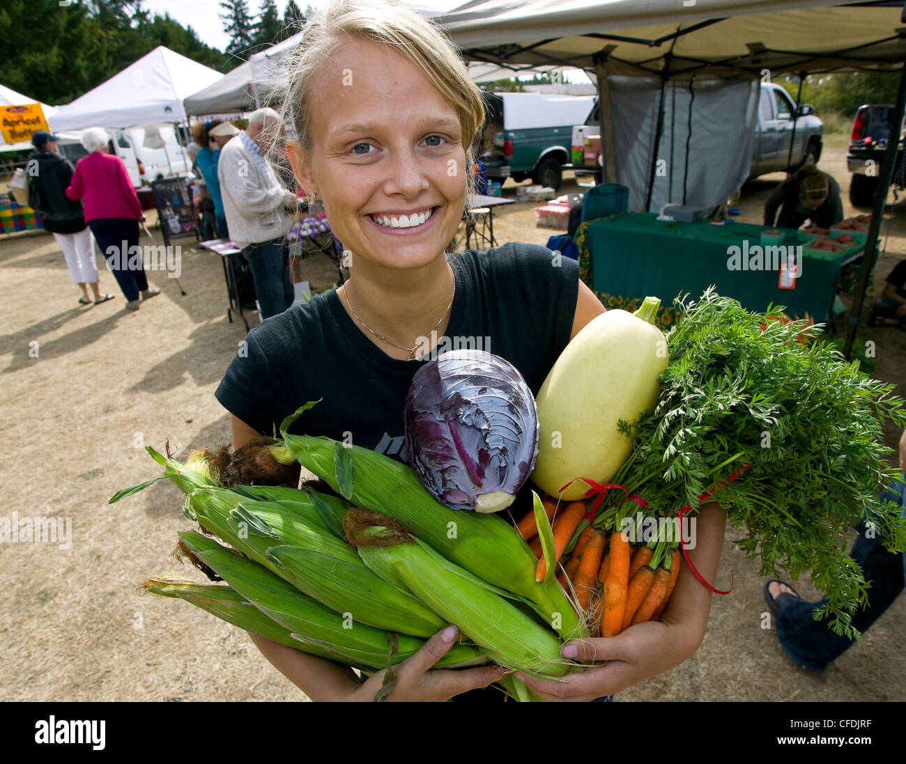 young vendor proudly displays fresh grown produce Stock Photo