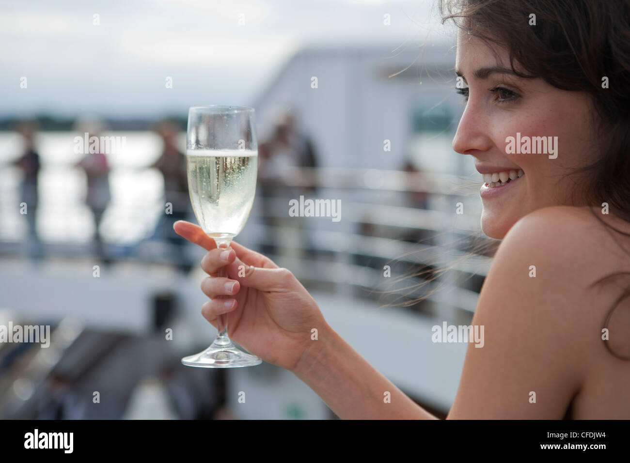 Woman holds champagne glass aboard cruise ship MS Astor (Transocean