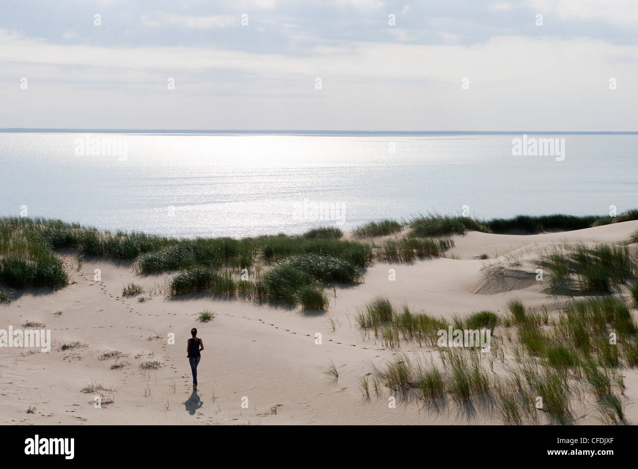 Woman strolls along sand dune on Curonian Spit [MR], near Klaipeda, Klaipedos, Lithuania Stock Photo