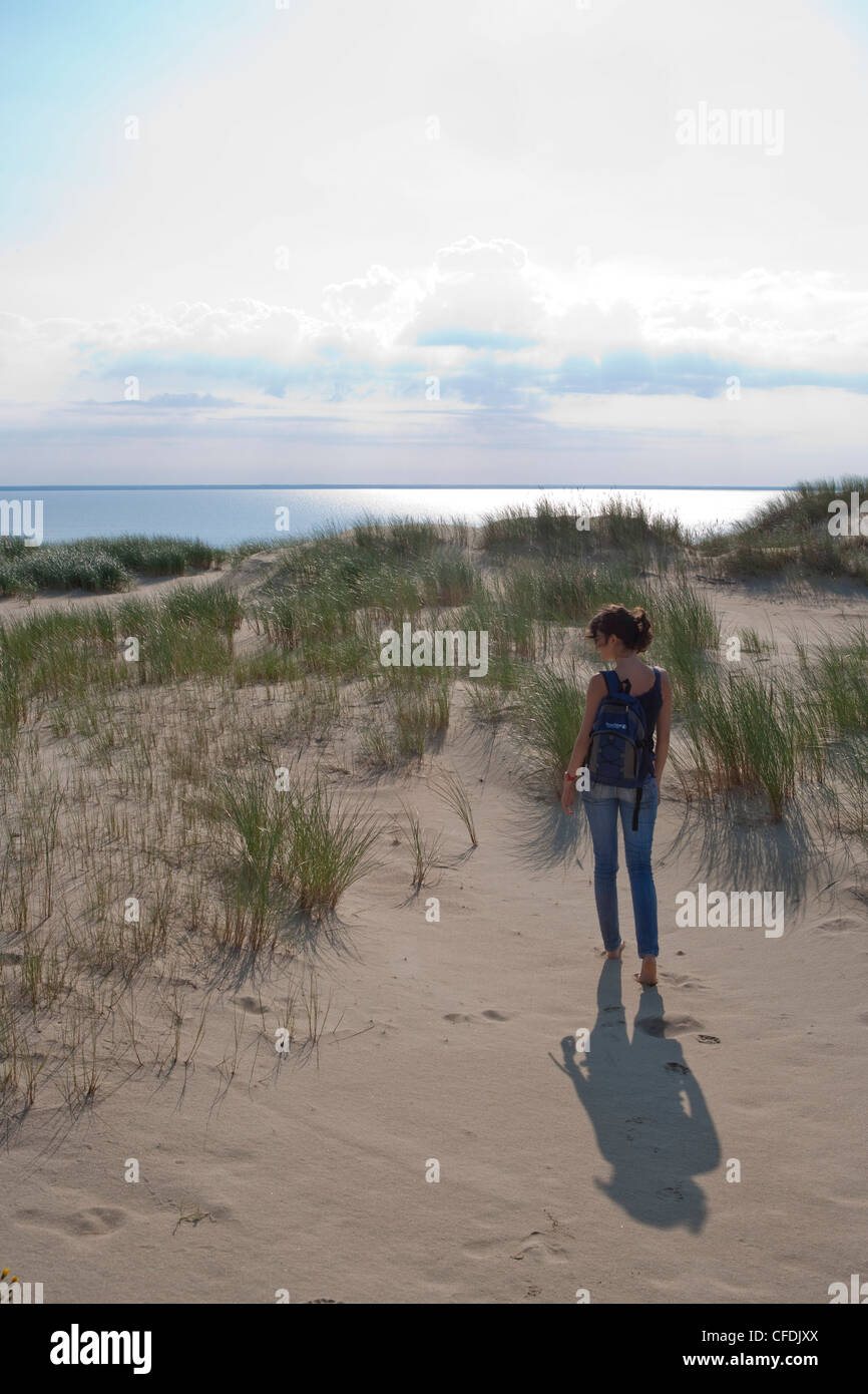 Woman strolls along sand dune on Curonian Spit [MR], near Klaipeda, Klaipedos, Lithuania Stock Photo