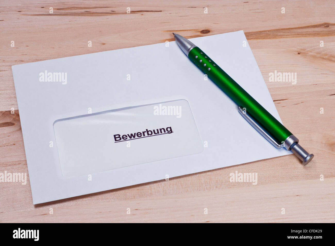 ein Briefumschlag mit einer Bewerbung, ein Stift liegt dabei | a envelope with a letter of application, a pen is alongside Stock Photo