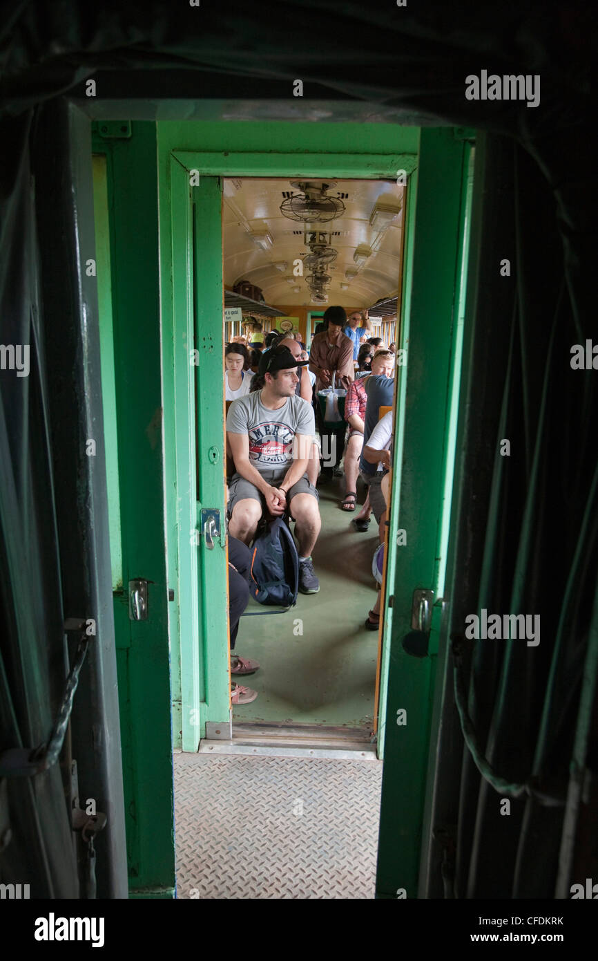 People in tourist train carriage on Trans River Kwai Death Railway, near Kanchanaburi, Thailand Stock Photo