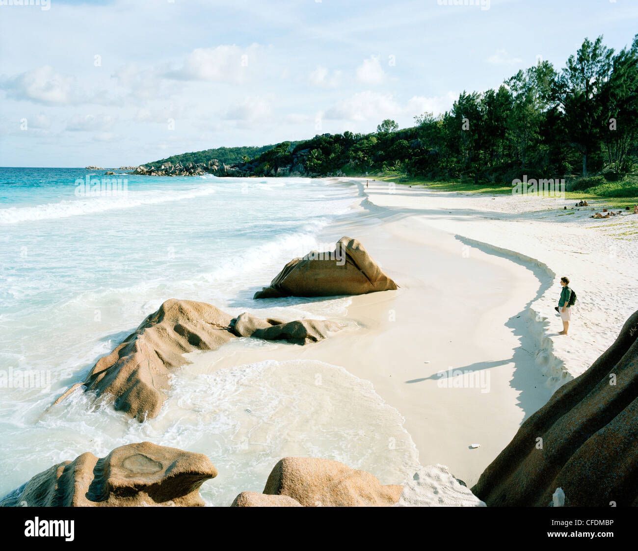 Woman on the beach Petite Anse, south eastern La Digue, La Digue and Inner Islands, Republic of Seychelles, Indian Ocean Stock Photo