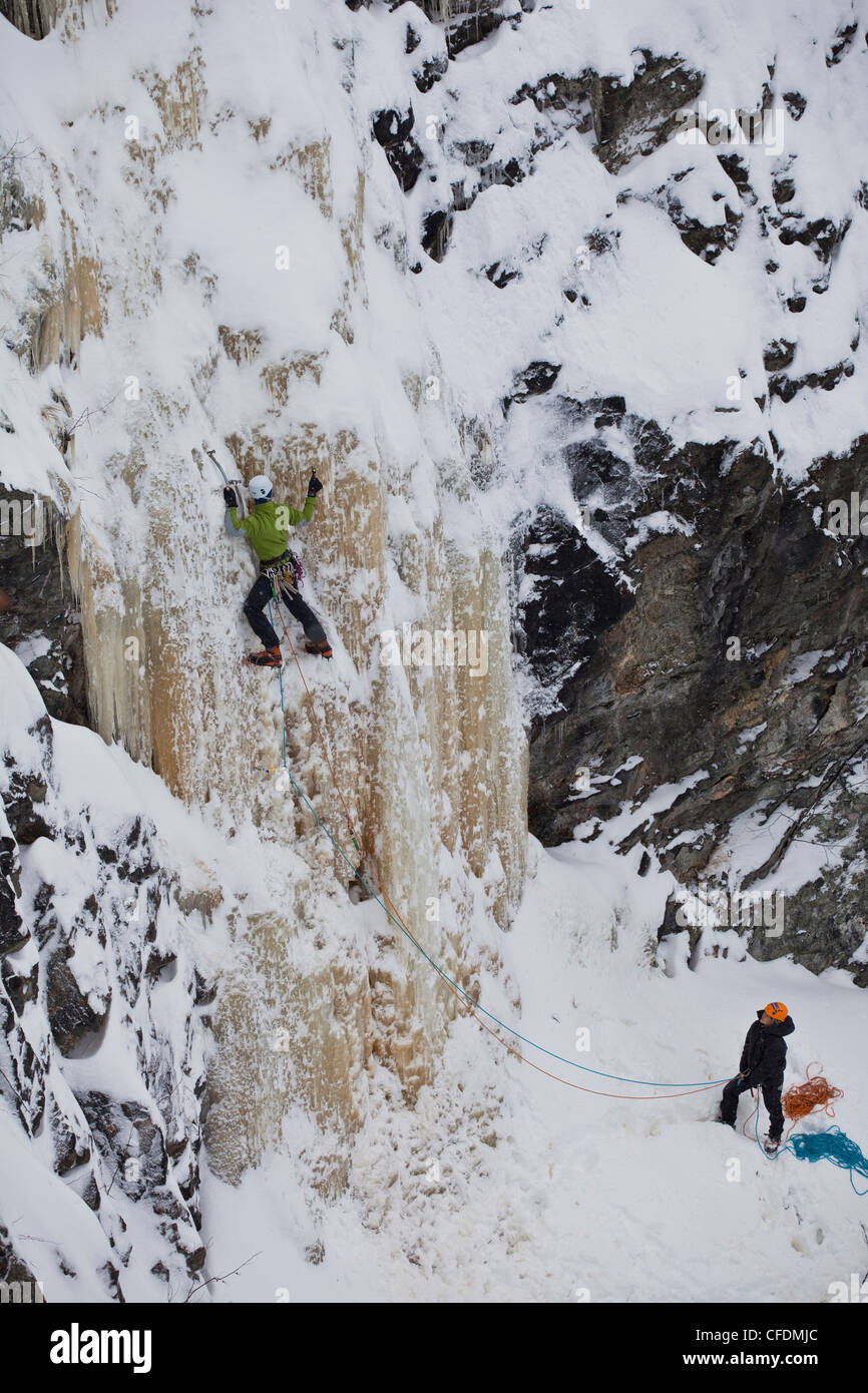 A young man ice climbing some grade 4 ice outside of Sherbrooke, Quebec, Canada Stock Photo
