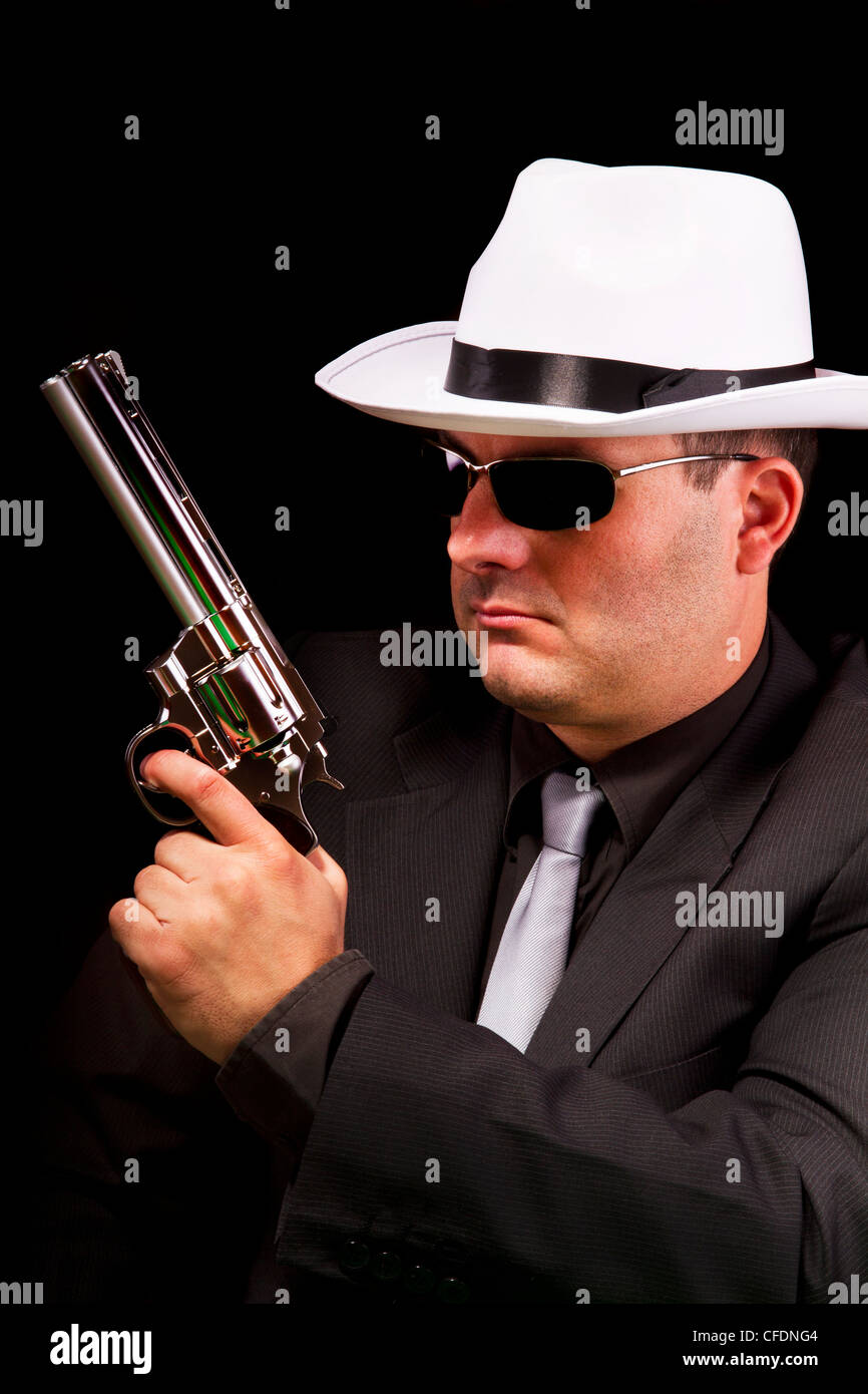View of a dark suit gangster man holding a gun Stock Photo - Alamy