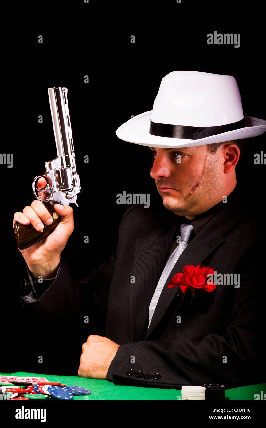 View of a dark suit gangster man holding a gun Stock Photo - Alamy