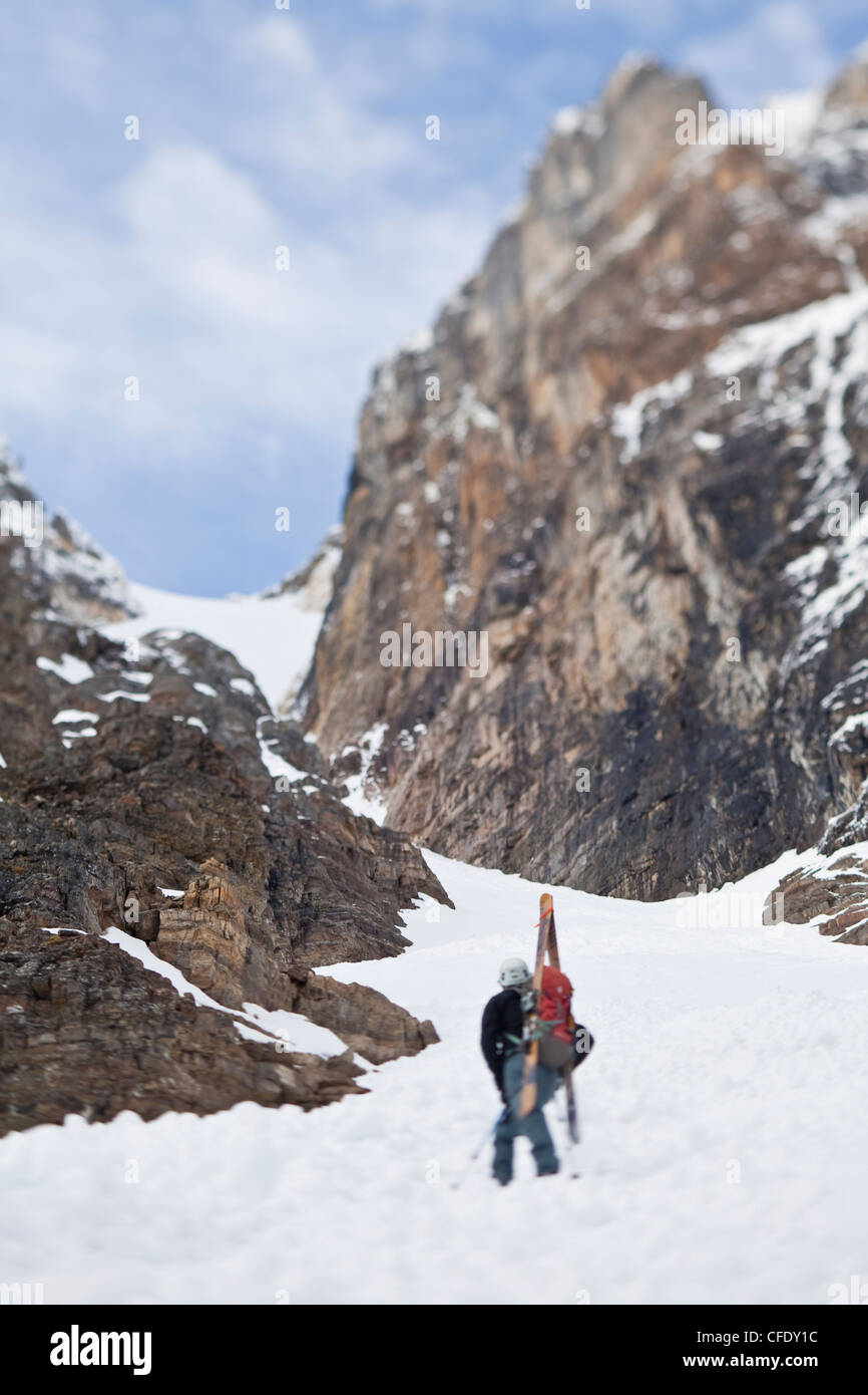 A male backcountry skiers bootpack up a steep spring couloir. 3/4 couloir, Moraine Lake, Banff National Park, Alberta, Canada Stock Photo