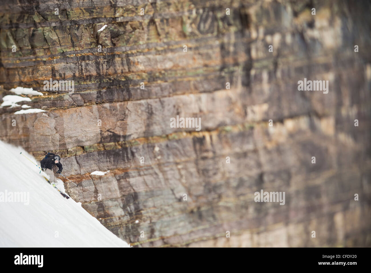 A male backcountry skier descends 3/4 Couloir in spring time conditions, Moraine Lake, Banff National Park, Alberta, Canada Stock Photo