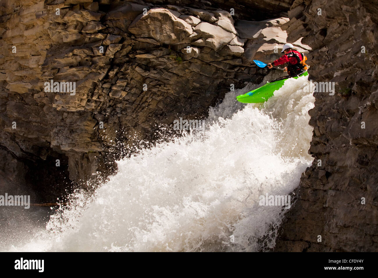 A male whitewater kayaker blasts through a waterfall on the Big Horn River, Nordegg, Alberta, Canada Stock Photo