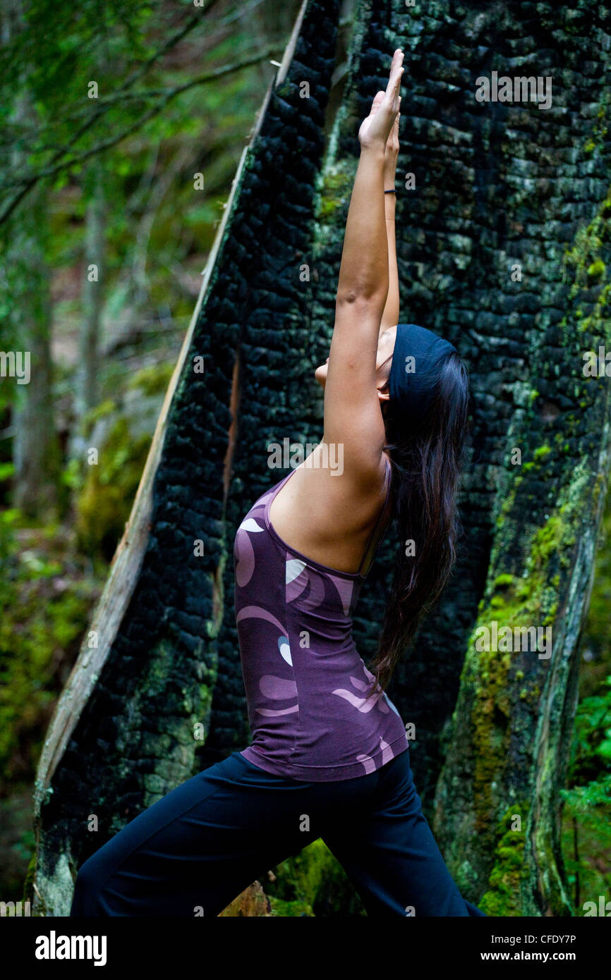 A woman practices yoga near the Clearwater River, Clearwater, British Columbia, Canada Stock Photo