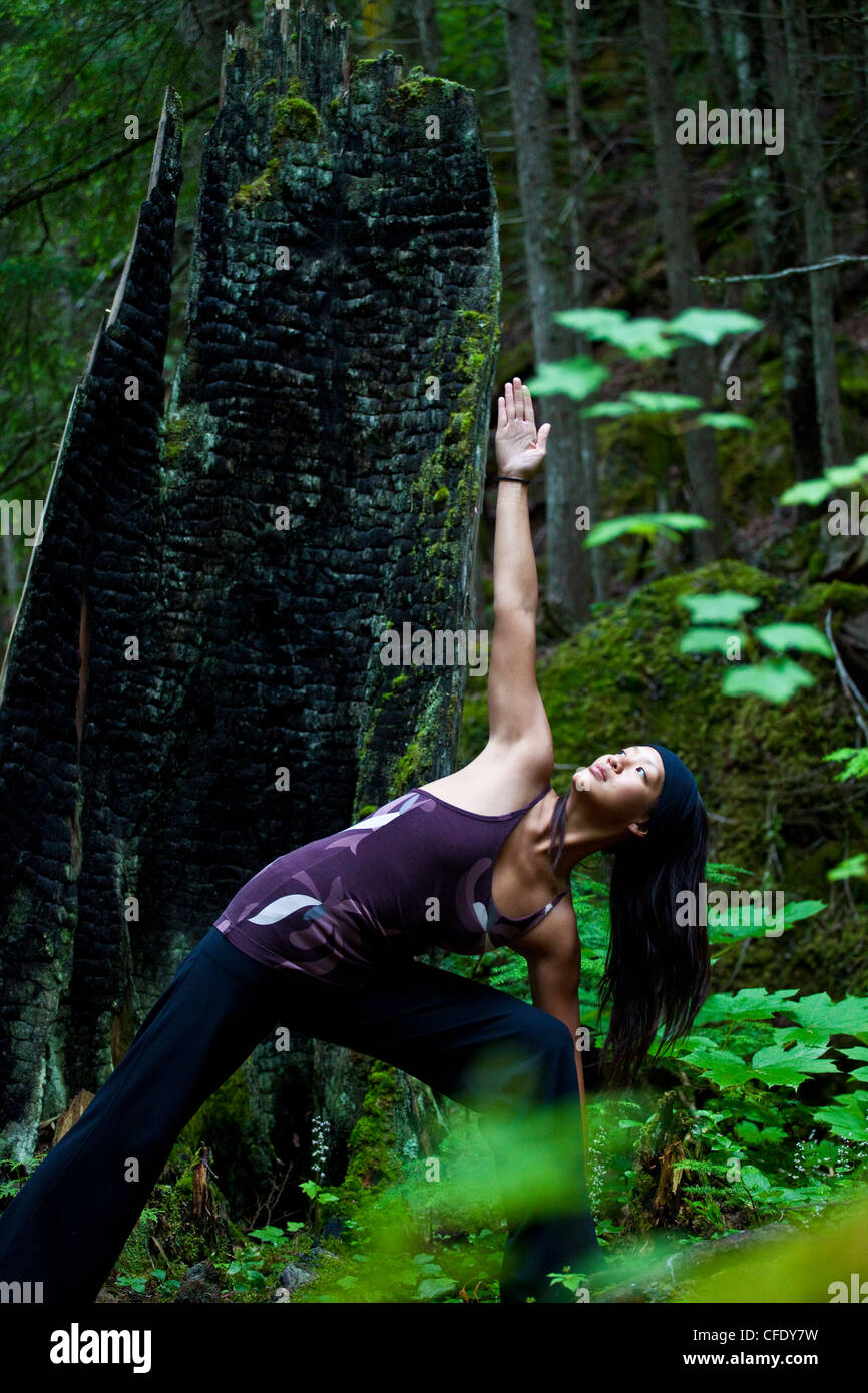 A woman practices yoga near the Clearwater River, Clearwater, British Columbia, Canada Stock Photo