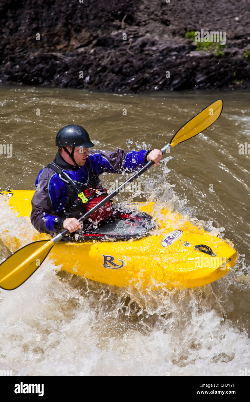 A man whitewater kayaking through a challenging rapid. Highwood River, Alberta, Canada Stock Photo