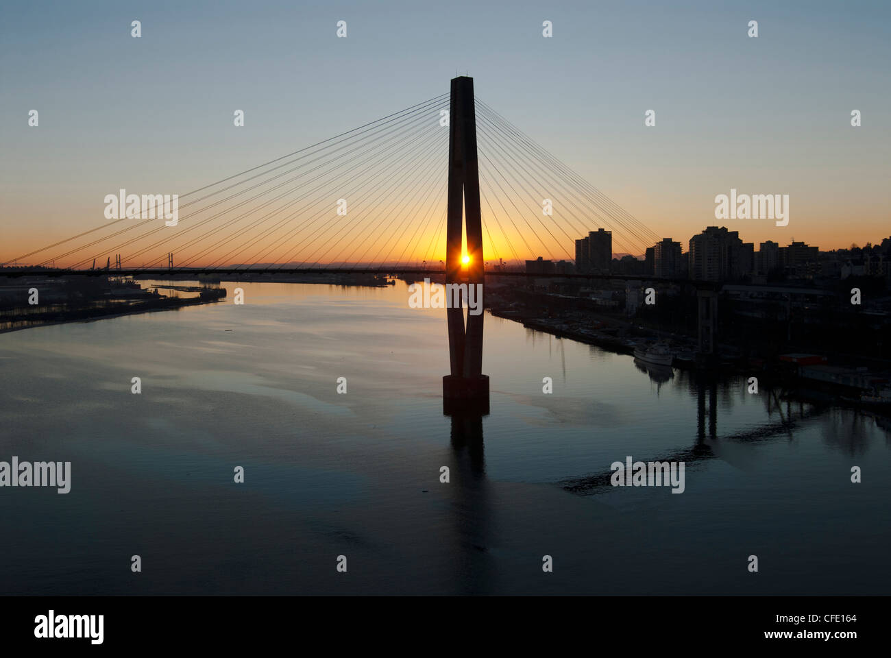 Sunset behind the Skytrain Bridge and the Fraser River in New Westminster, British Columbia, Canada. Stock Photo