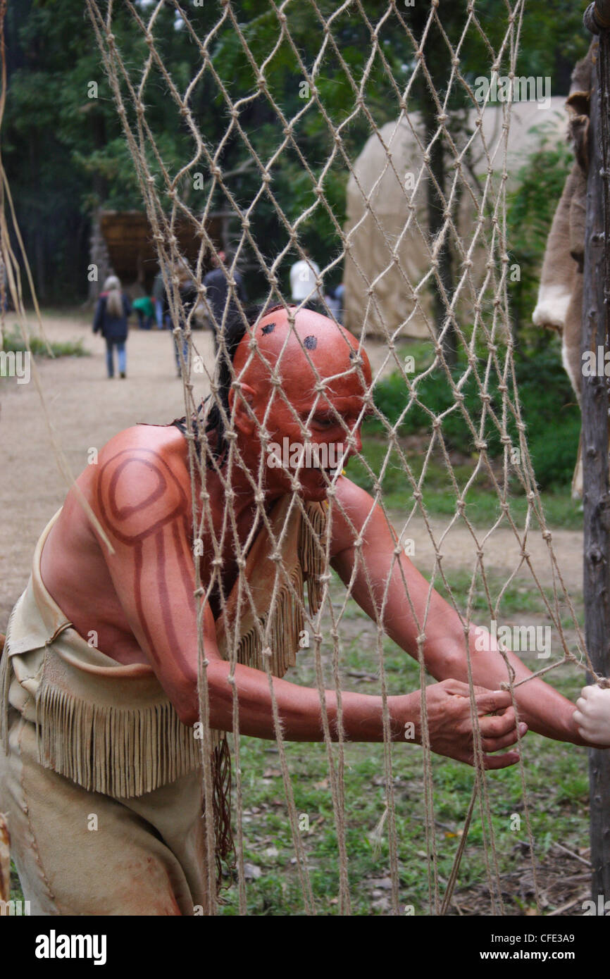 Historical re-enactor in Henricus,Virginia illustrating how Native Americans made fishing nets in the 1600's. Stock Photo