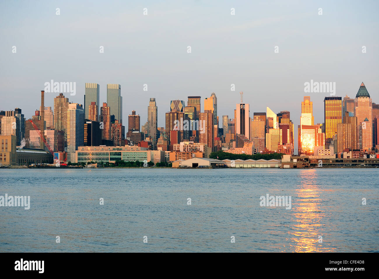 New York City Manhattan midtown skyline at sunset with reflection over ...