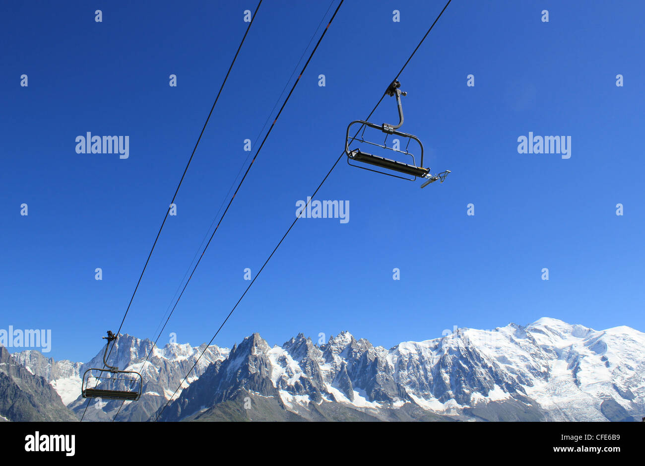 Two chair lifts and MontBlanc mountains behind, France, by very