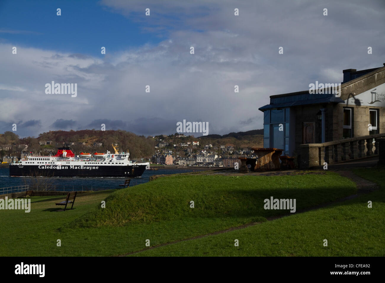 A passenger ferry in Oban, West Coast of Scotland, from Dungallan Park with the Seafood Temple restaurant in the foreground Stock Photo