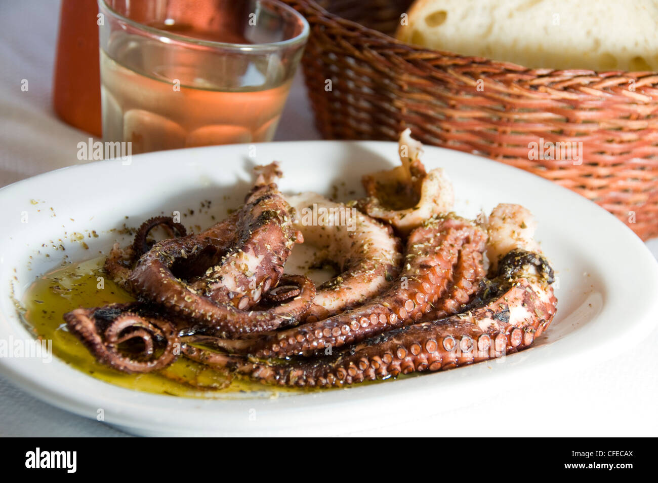 marinated octopus house wine metal carafe with crusty bread as photographed in Greek Island Antiparos taverna Greece specialty f Stock Photo