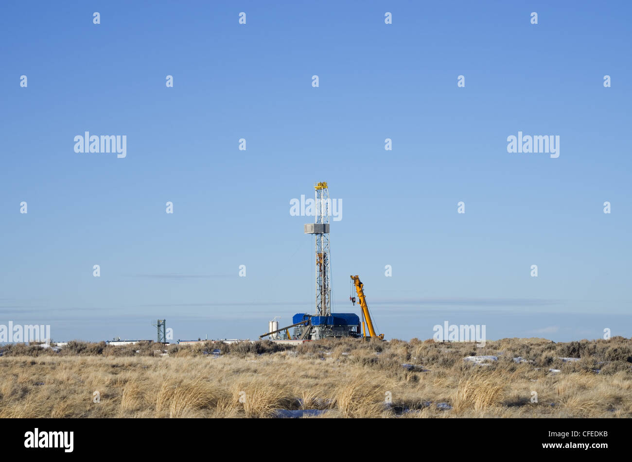 distant drill rig set up for winter drilling in Wyoming Stock Photo