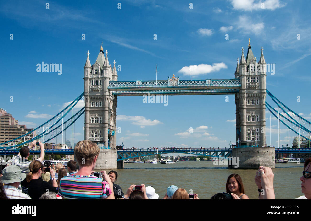 Tourists on Thames cruise taking photos of Tower Bridge, London. Stock Photo