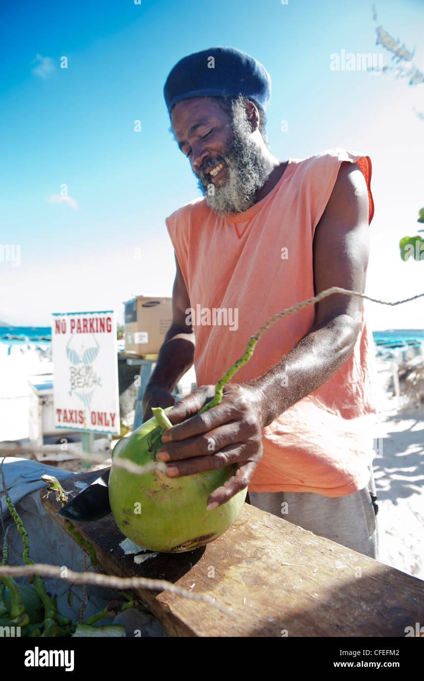 Bearded Black Rastafarian Coconut vendor, Orient Beach, Saint-Martin, West Indies Stock Photo